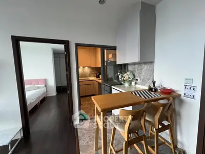 Modern kitchen with breakfast bar and view into cozy bedroom