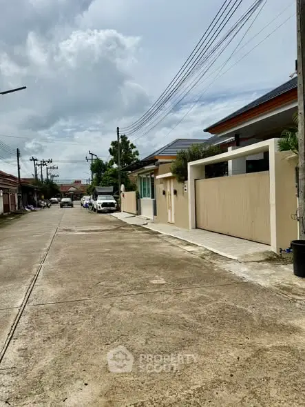 Charming residential street view with modern houses and clear skies, perfect for serene living.
