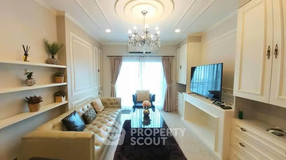 Elegant living room with chandelier, plush sofa, and modern decor in a luxurious apartment.