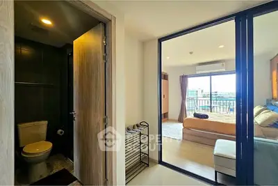 Modern apartment with bedroom and bathroom, featuring a balcony view.