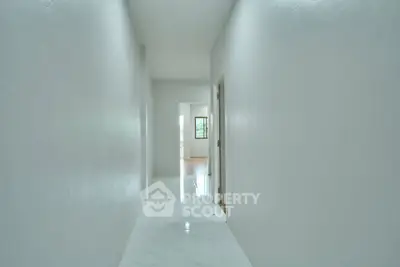 Bright hallway leading to a sunlit room with modern minimalist design.