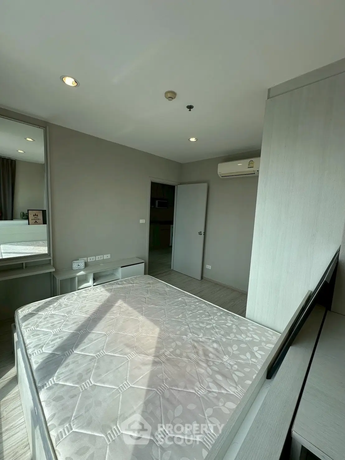 Modern bedroom with natural light and air conditioning in a stylish apartment.