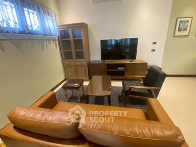 Cozy living room with leather sofa, TV, and wooden cabinet in modern home.