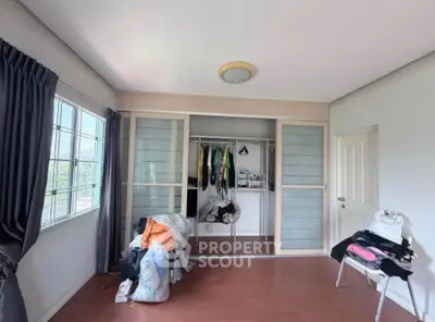 Spacious bedroom with large window and built-in closet, featuring natural light and modern design.