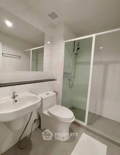 Modern bathroom with sleek shower and elegant fixtures in a contemporary apartment.