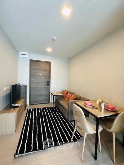 Modern living room with cozy seating and dining area in stylish apartment.