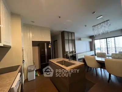 Modern open-layout kitchen and dining area with elegant chandelier and balcony view.