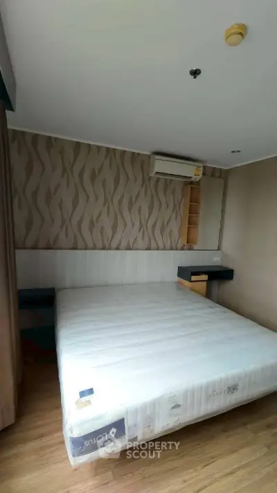 Modern bedroom with stylish wallpaper and air conditioning in a cozy apartment.