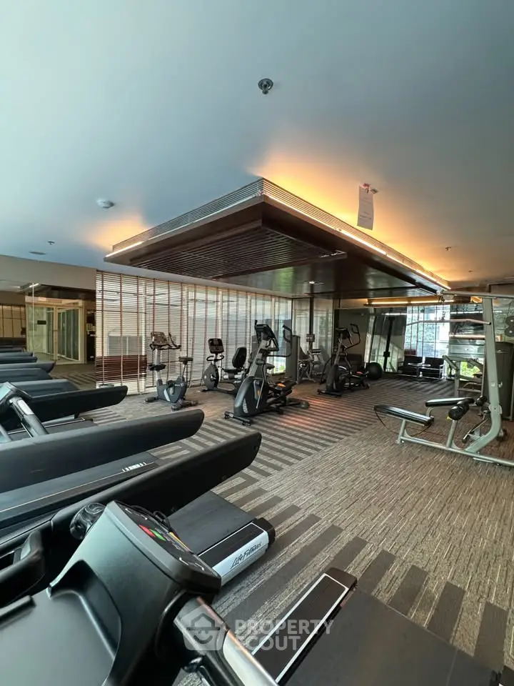 Luxurious gym with modern fitness equipment in upscale residential building.