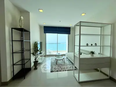 Modern living room with ocean view, sleek furniture, and natural light