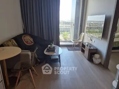 Modern living room with balcony view, stylish furniture, and natural light.