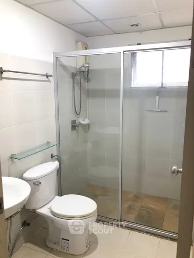 Modern bathroom with glass shower enclosure and white fixtures