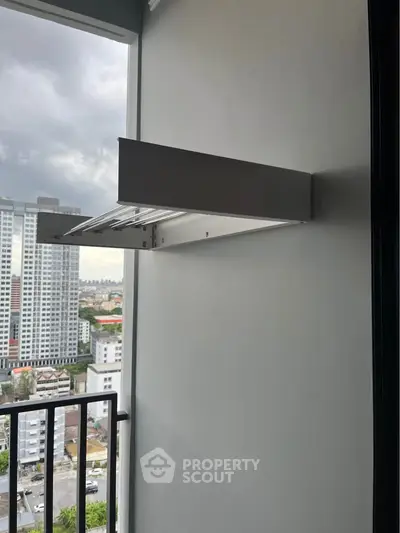Modern balcony with city view, featuring sleek wall-mounted drying rack.