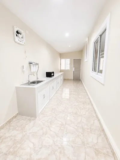 Spacious kitchen with sleek countertops and modern appliances in a bright, airy setting.