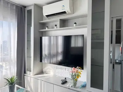 Modern living room with sleek TV setup and air conditioning, featuring stylish decor and ample natural light.