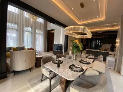 Luxurious open-plan living and dining area with elegant decor and modern lighting