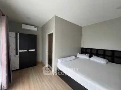 Spacious bedroom with modern furnishings and ample natural light, featuring a large bed and stylish wardrobe.