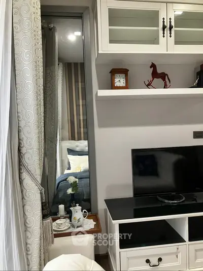 Charming living room with elegant decor and cozy ambiance, featuring a stylish TV setup and decorative shelves.
