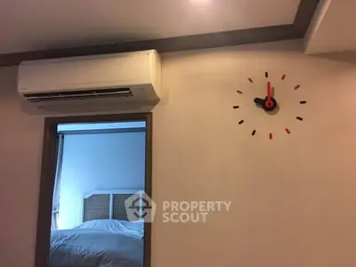 Modern bedroom with air conditioning and stylish wall clock, showcasing comfort and contemporary design.