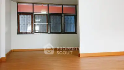 Spacious empty room with large windows and wooden flooring