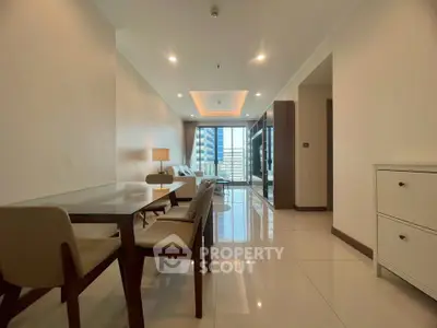 Spacious modern living room with dining area and city view, featuring elegant furniture and bright lighting.