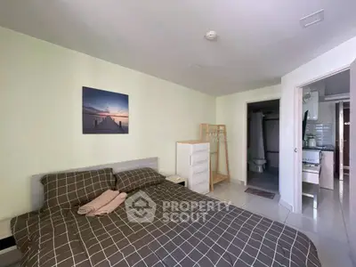 Cozy bedroom with modern decor and ensuite bathroom in a stylish apartment.