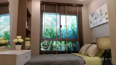 Cozy bedroom with large window and modern decor, perfect for relaxation and natural light.