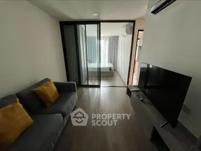 Modern apartment interior with cozy living room and bedroom view, featuring sleek furniture and natural lighting.