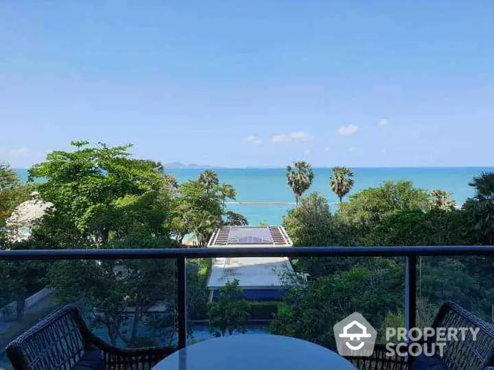 Stunning ocean view from balcony with lush greenery and clear blue sky