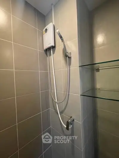 Modern bathroom with sleek shower unit and glass shelves, perfect for contemporary living.