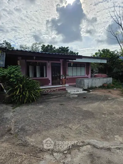Charming single-story home with spacious front yard and lush greenery, perfect for serene living.