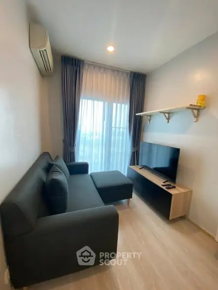 Cozy living room with modern sofa and TV, perfect for relaxation.