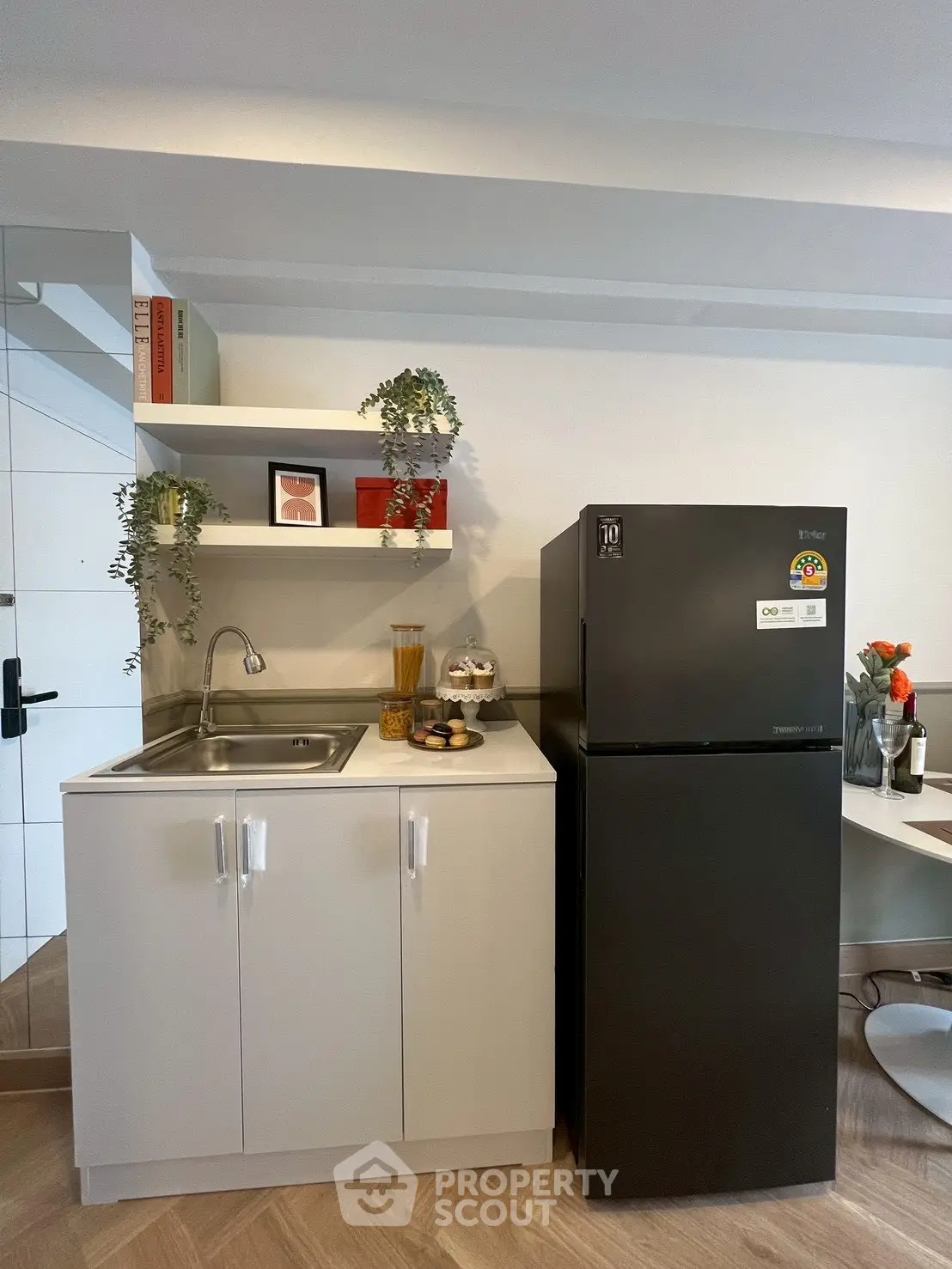 Modern compact kitchen with sleek black fridge and stylish decor