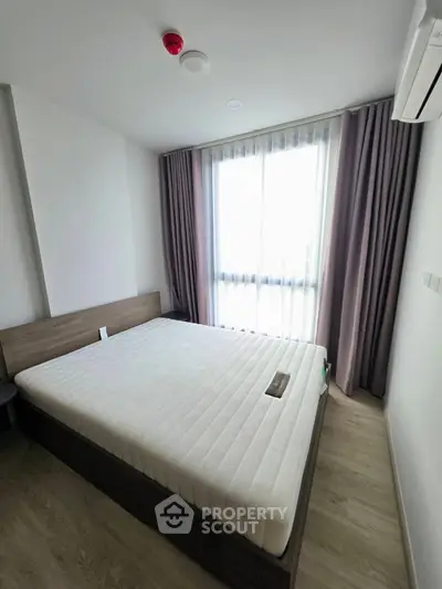 Modern bedroom with large window and minimalist design in a stylish apartment.