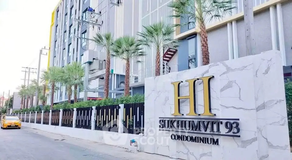 Modern condominium exterior with palm trees and stylish facade at Sukhumvit 93.