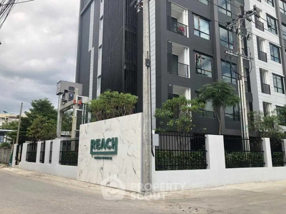 Modern apartment building exterior with sleek design and lush greenery