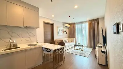 Modern open-layout living room with kitchen, featuring elegant decor and natural light.