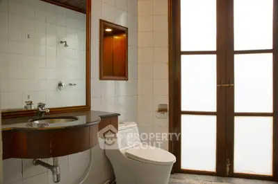 Elegant bathroom with modern fixtures and large frosted glass window for natural light.