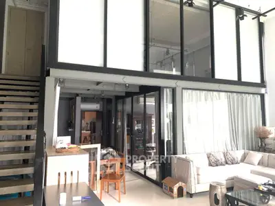 Spacious modern living room with mezzanine, large windows, and stylish furniture in a contemporary home.