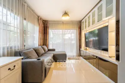 Modern living room with sleek design, large TV, and cozy gray sofa.
