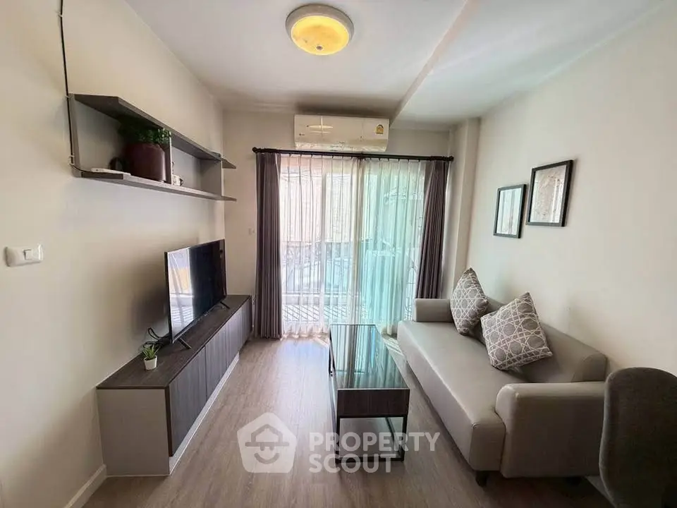Modern living room with stylish decor and natural light, featuring a cozy sofa and entertainment unit.