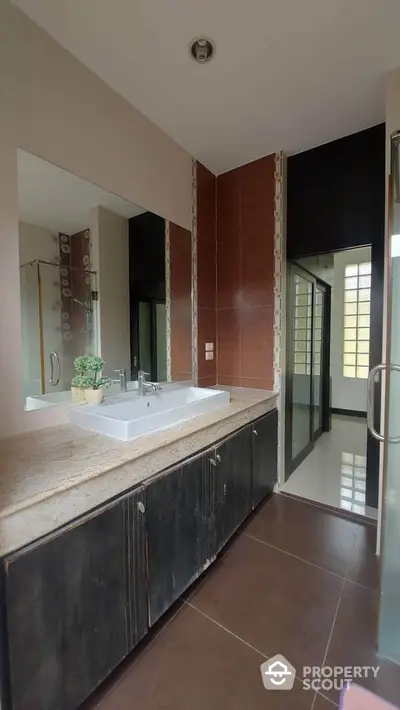 Modern bathroom with sleek design and large mirror in a stylish home.