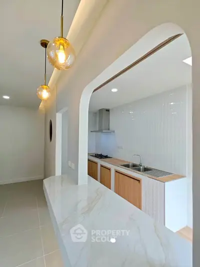 Modern kitchen with open layout and elegant lighting fixtures