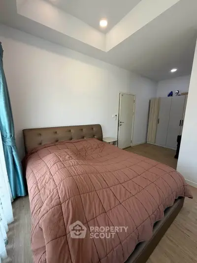 Cozy bedroom with modern furnishings and ample natural light, perfect for relaxation.