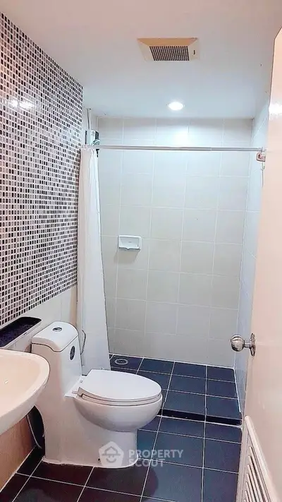 Modern bathroom with sleek design and tiled shower area, perfect for a contemporary home.