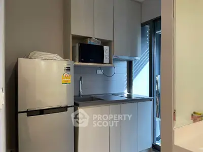 Modern kitchen with sleek cabinetry and stainless steel appliances in a compact layout.