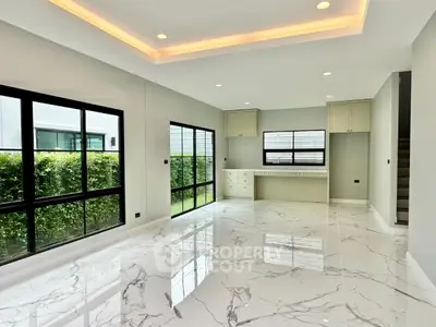 Spacious modern living room with marble flooring and large windows overlooking greenery.