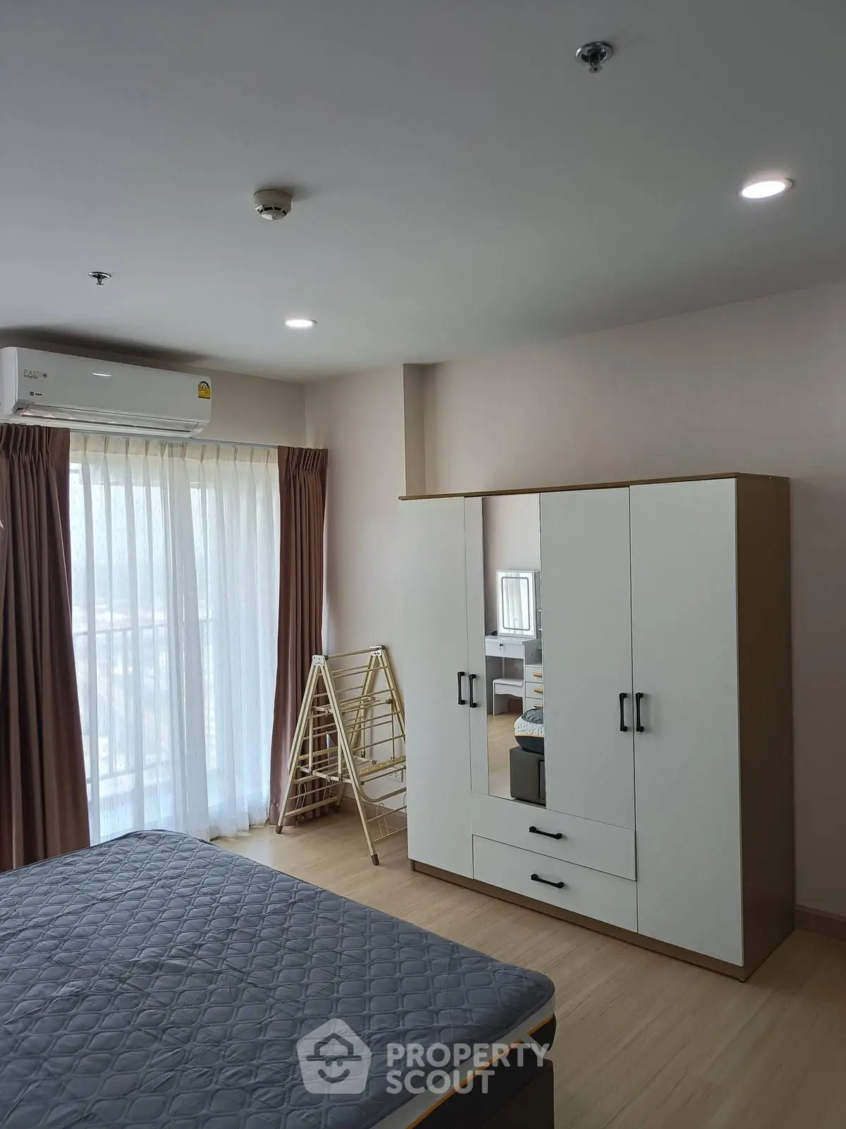 Modern bedroom with large wardrobe and natural light from window