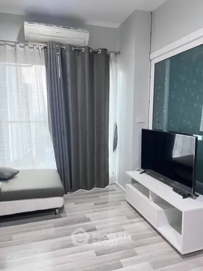 Modern living room with sleek TV setup and stylish gray curtains