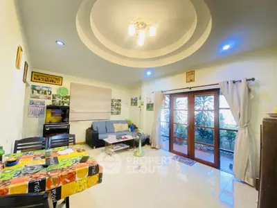 Spacious living room with modern lighting and large windows opening to a garden view.